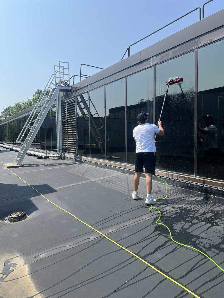 Window cleaning in progress along a large commercial glass frontage
