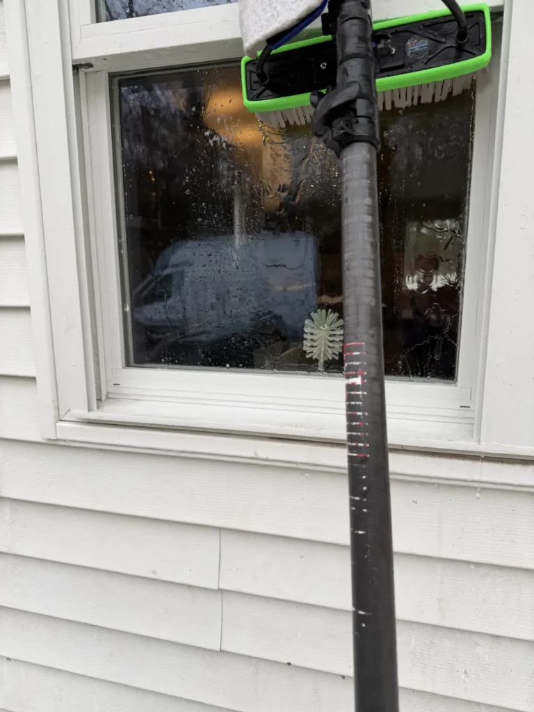 Water-fed brush cleaning exterior window glass