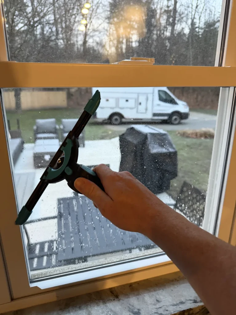 Squeegee cleaning the inside of a residential window