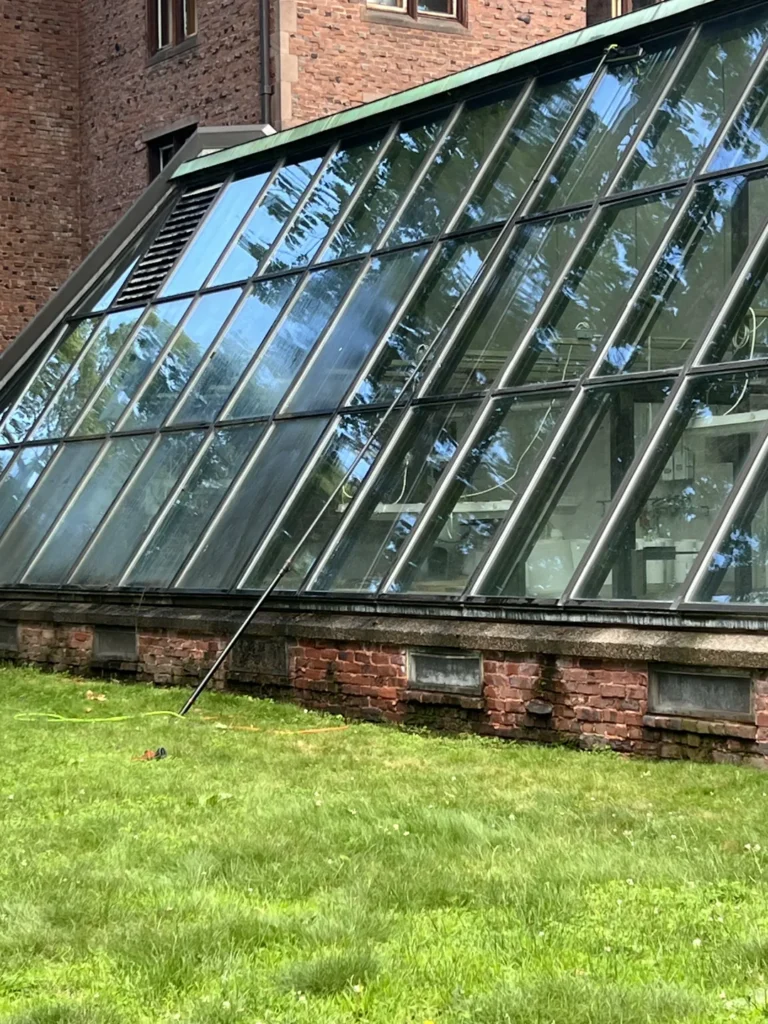 Sloped greenhouse-style glass with a water-fed cleaning pole